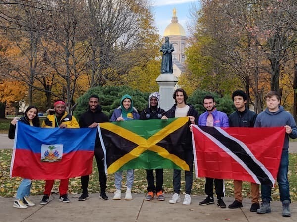 Caribsa Students holding flags in from of the Golden Dome